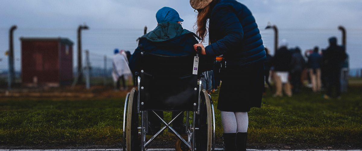 woman standing next to a woman in a wheelchair
